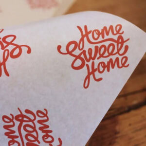Custom printed butcher paper with red cursive branding used for food wrapping and preparation.